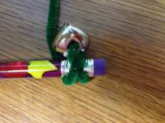 bell and pipe cleaner wrapped around the end of a pencil