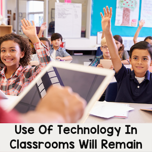 Use of technology in classrooms will remain. Teacher holding tablet and students raising hands