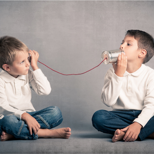 two boys using tin can telephones