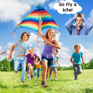 children flying a kite and chasing it.
